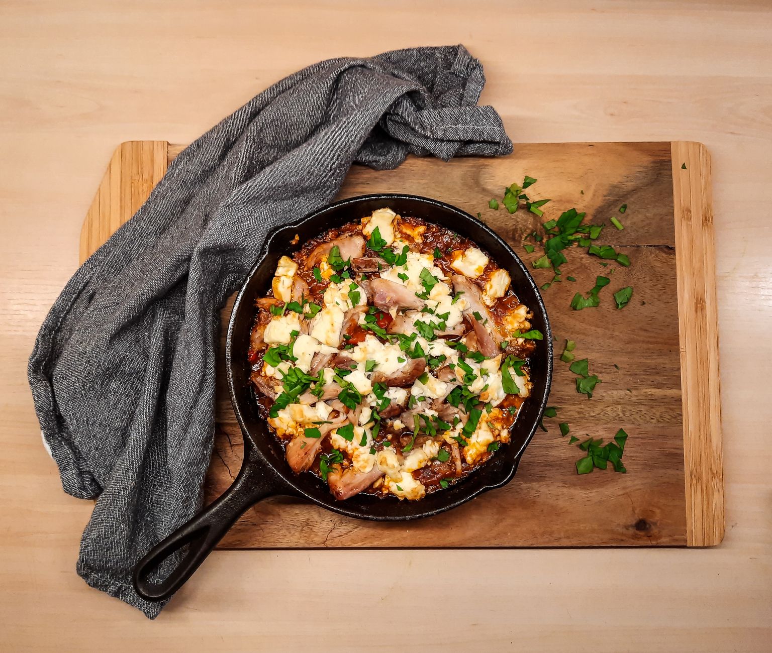 Cast iron on a wood board with oil and towel, a visual primer for cast iron skillet care